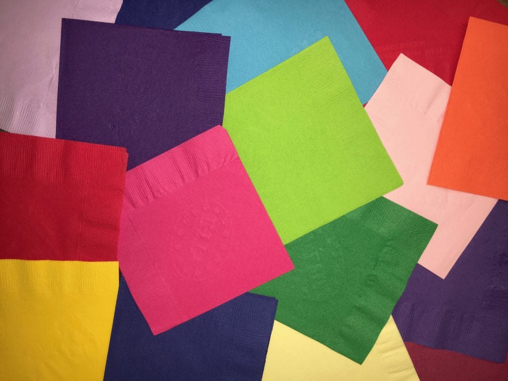 Scattered assortment of different colored beverage napkin