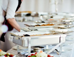 Caterer preparing buffet of food in serving dishes